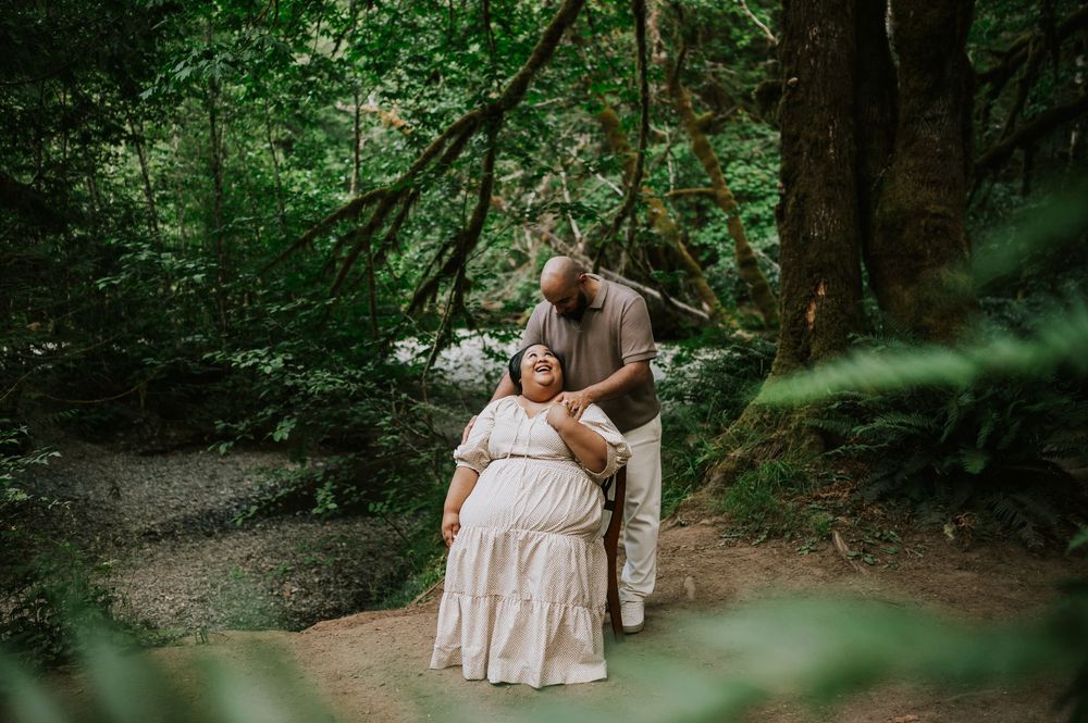 Photo of engaged couple sitting on chair in forest Cathedral Groves, MacMillan Park. Vancouver Island adventure photographer