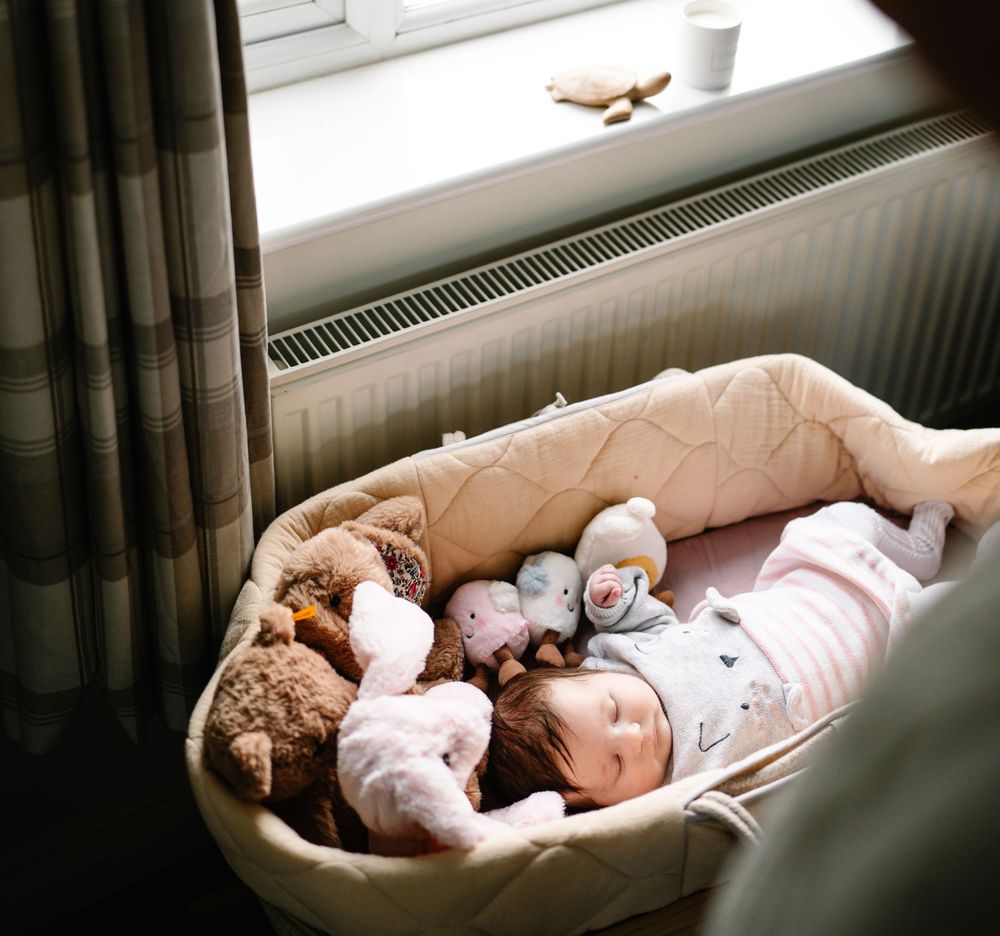 A series of photos showing a baby sleeping peacefully on a couch with a teddy bear companion.