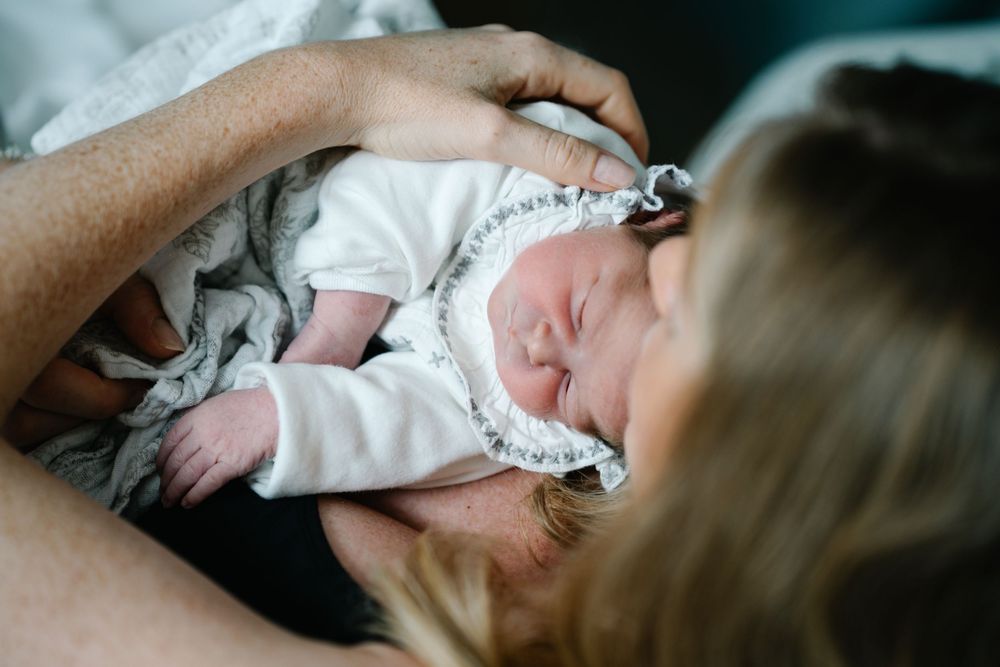 A tender moment with a sleeping newborn wearing delicate white lace.