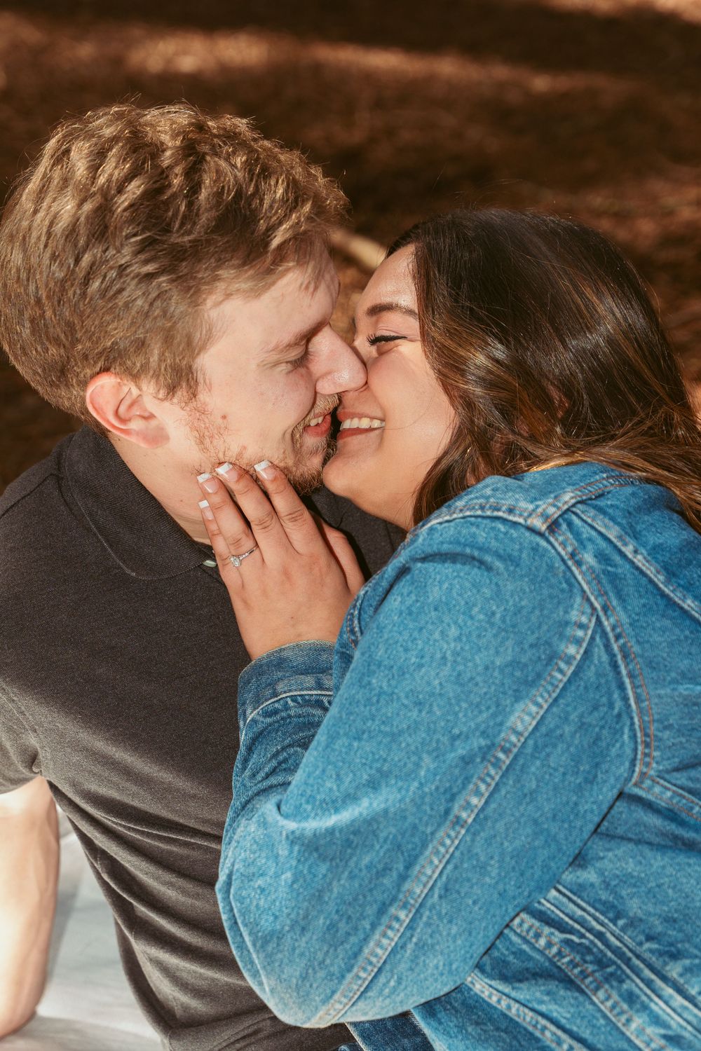 A romantic couple sharing an intimate moment while laughing and embracing in warm lighting.
