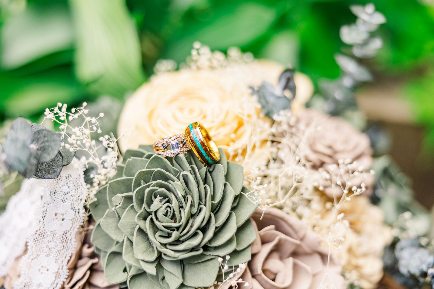 A wedding bouquet featuring a gray succulent, peach roses, and delicate baby's breath flowers in a romantic arrangement.