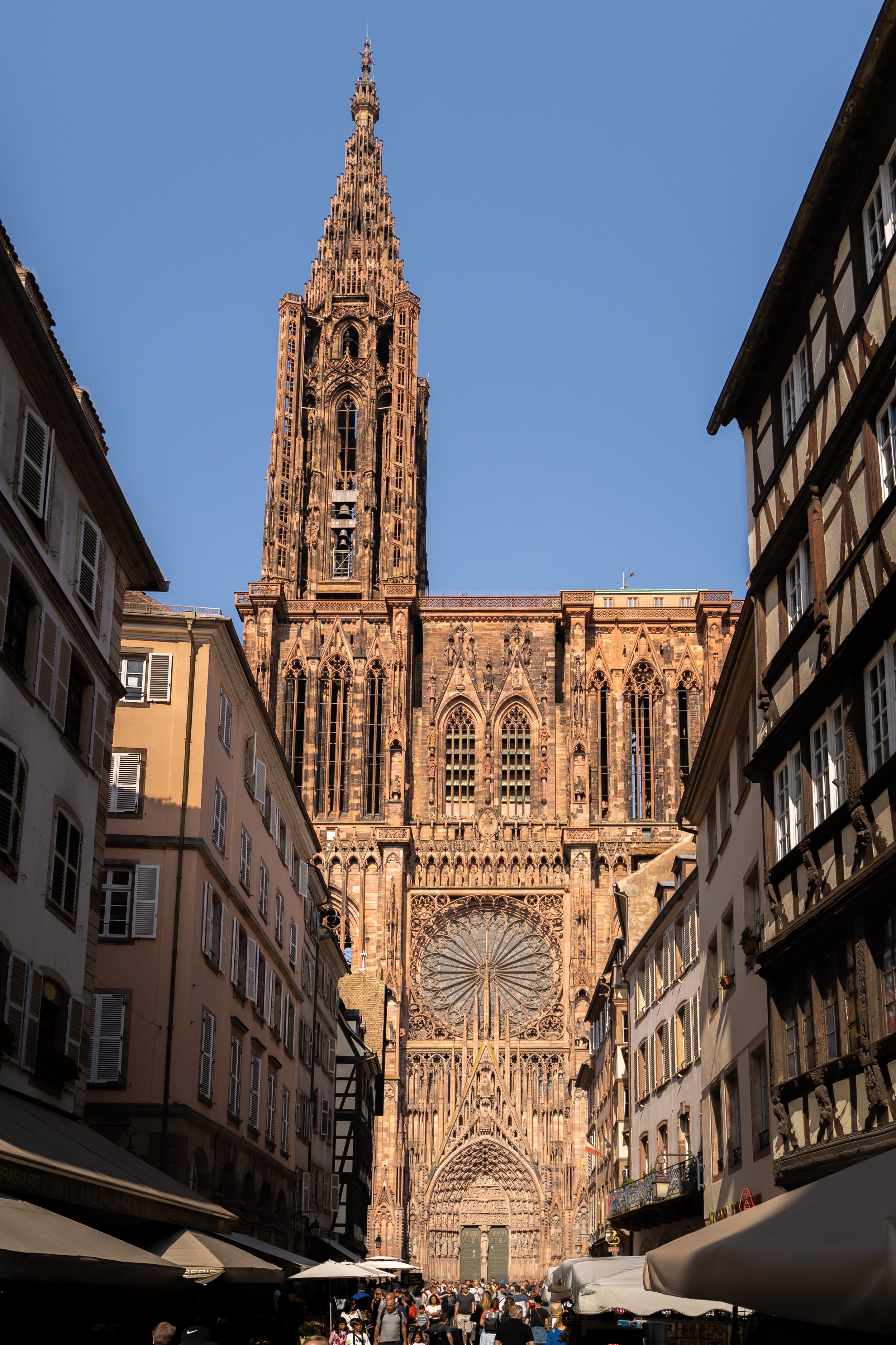 Gothic Strasbourg Cathedral towers over narrow medieval streets in France.
