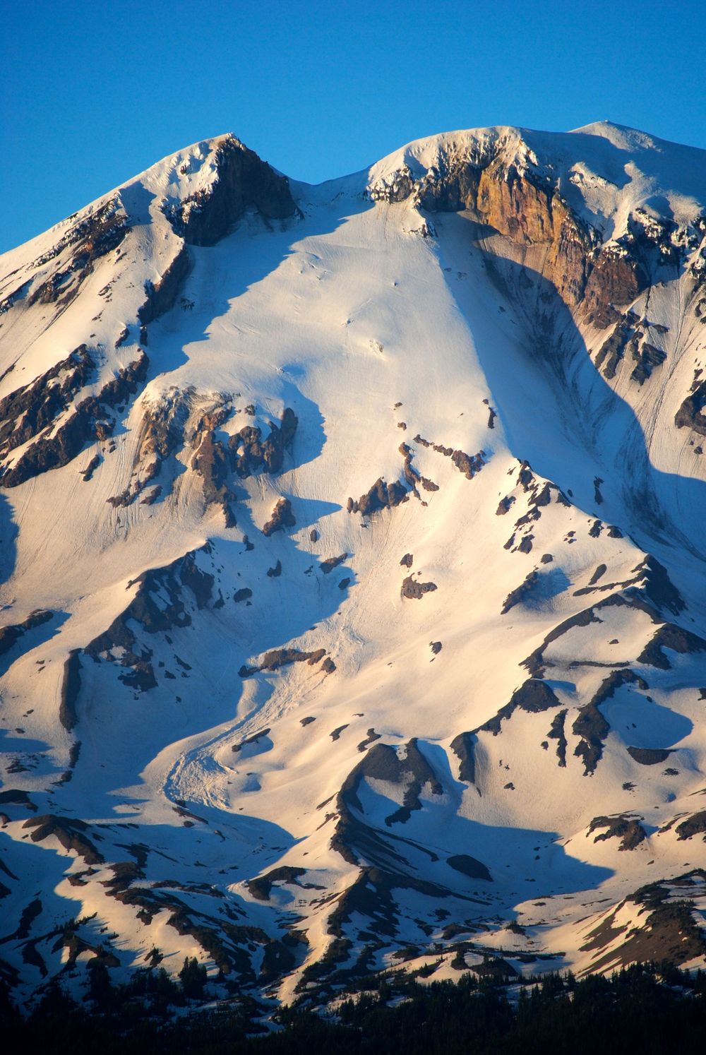 Snow-covered mountain peak with dramatic rock faces and glacial formations.
