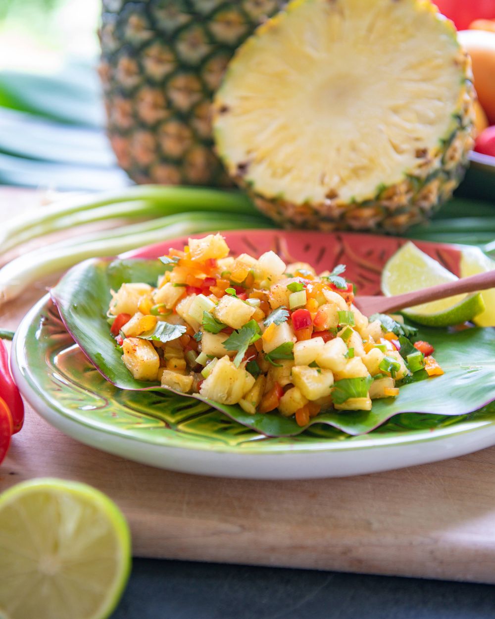 Fresh tropical pineapple salad served on banana leaf with lime garnish.
