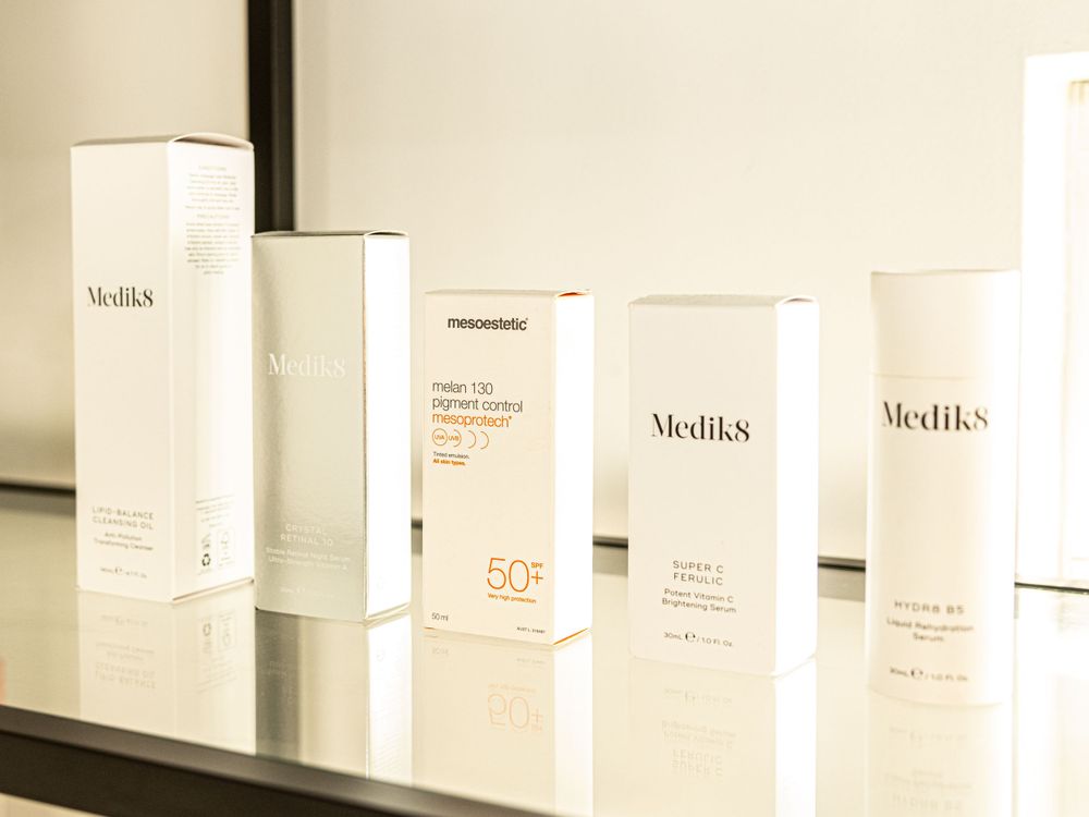 Collection of Medik8 skincare products arranged on a black display shelf.