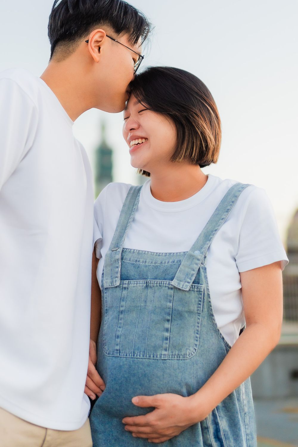 Intimate moment shared on urban rooftop with city skyline in background.