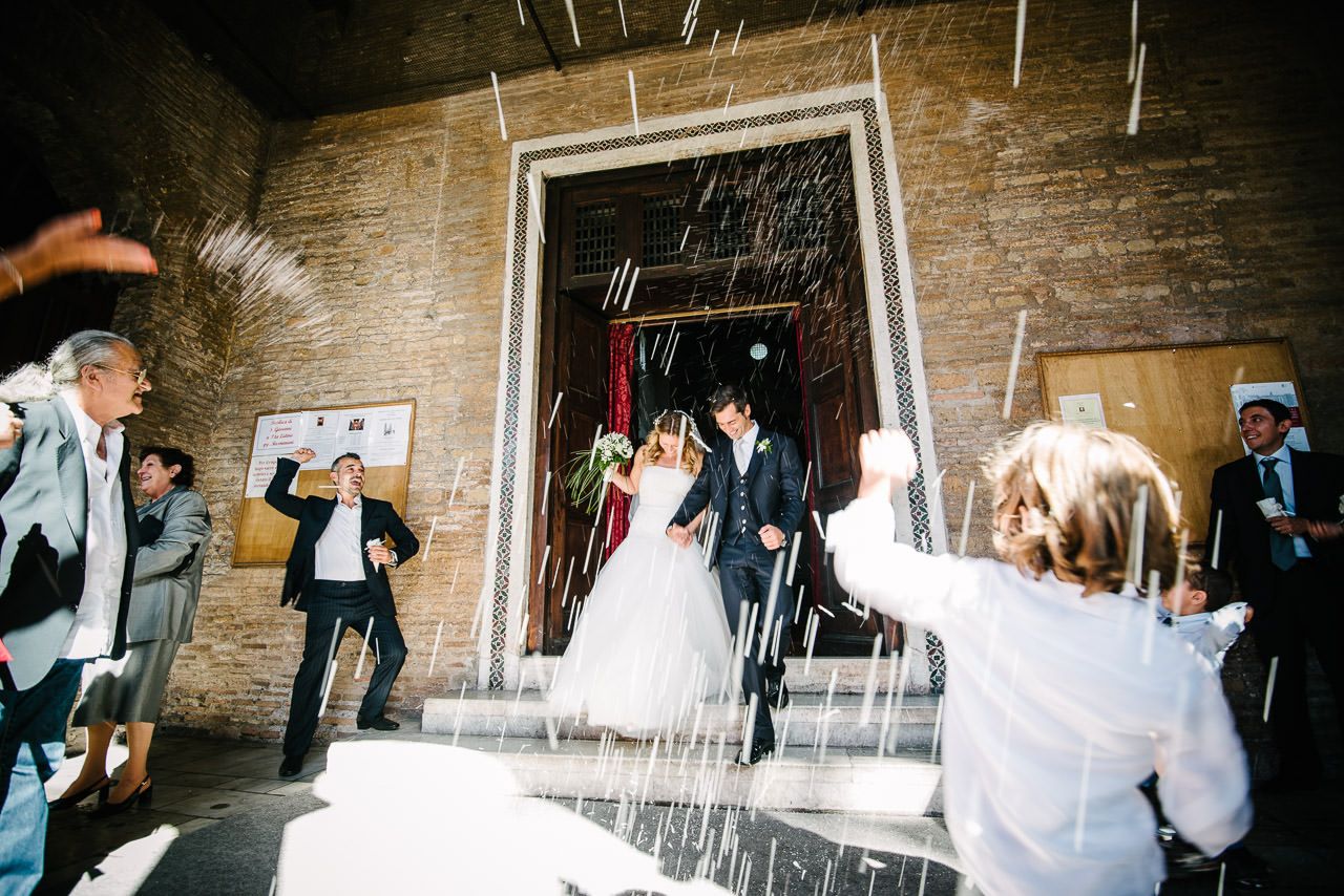 Wedding party celebrations inside a rustic brick-walled venue.