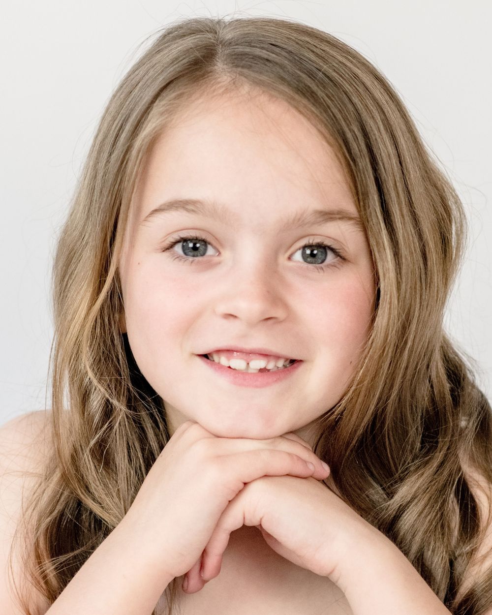 Studio headshot with soft lighting and natural pose.