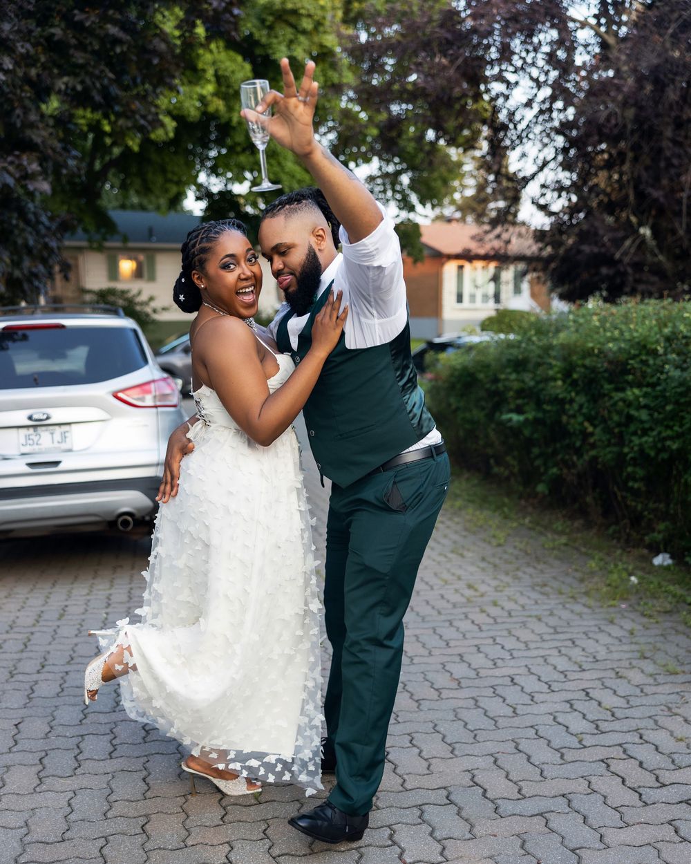 A joyful wedding dance moment outdoors with the couple sharing a laugh.
