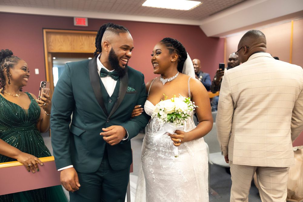 Wedding couple sharing a joyful moment with guests in a reception hall.
