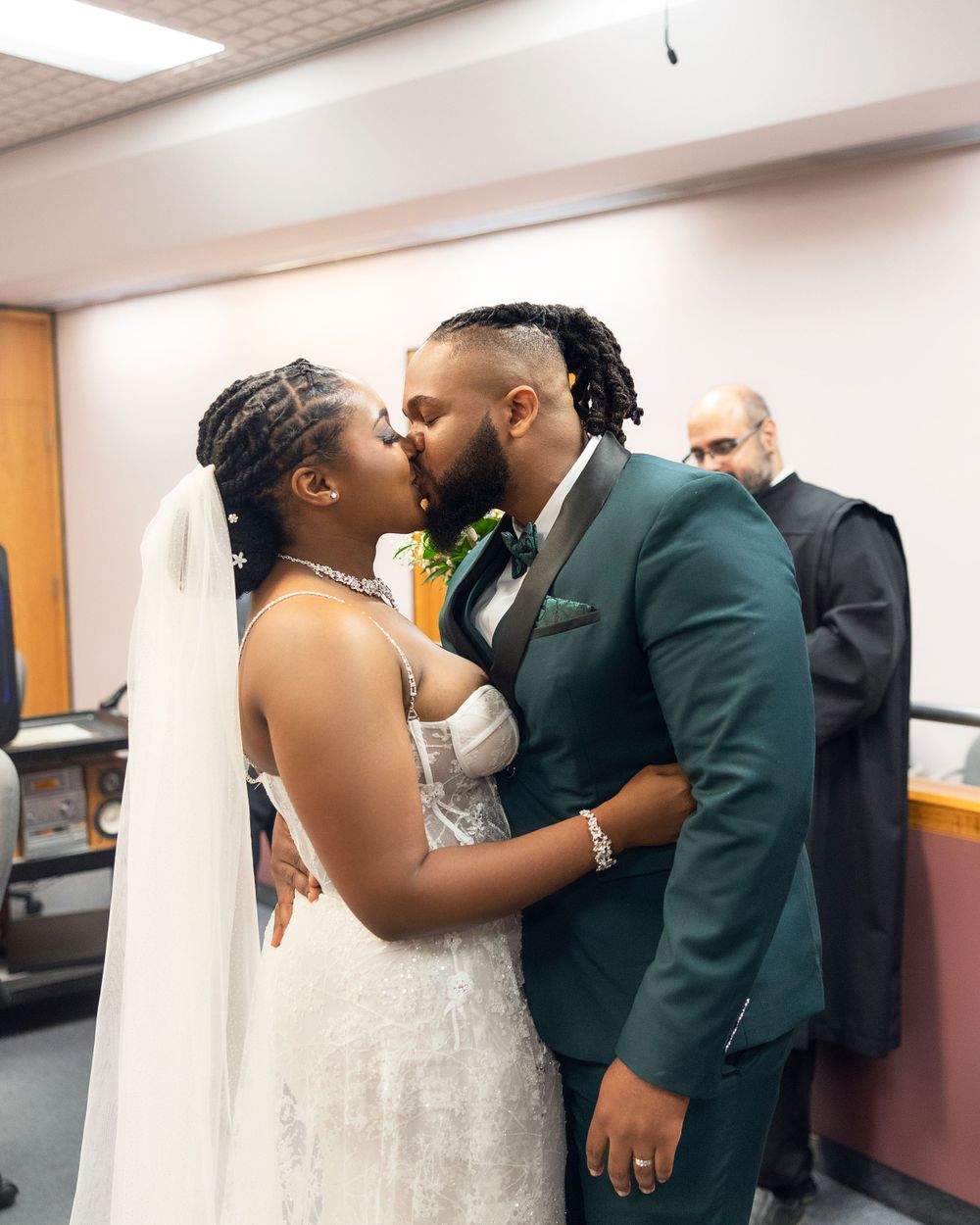 An intimate wedding moment shared in an indoor hallway setting.