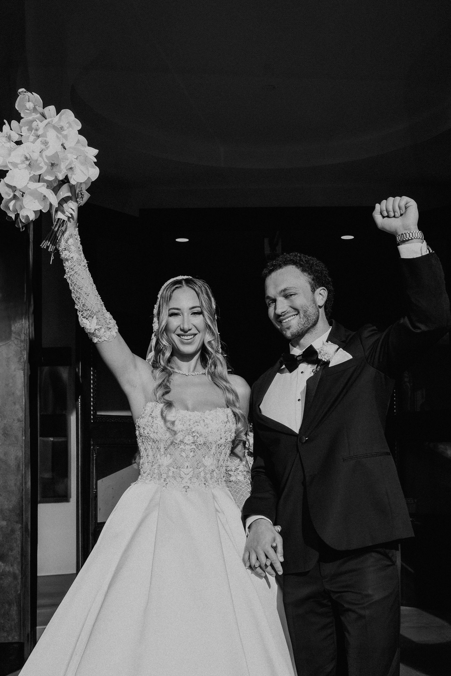 Dreamy wedding scene through bokeh lights with colorful floral arch backdrop.