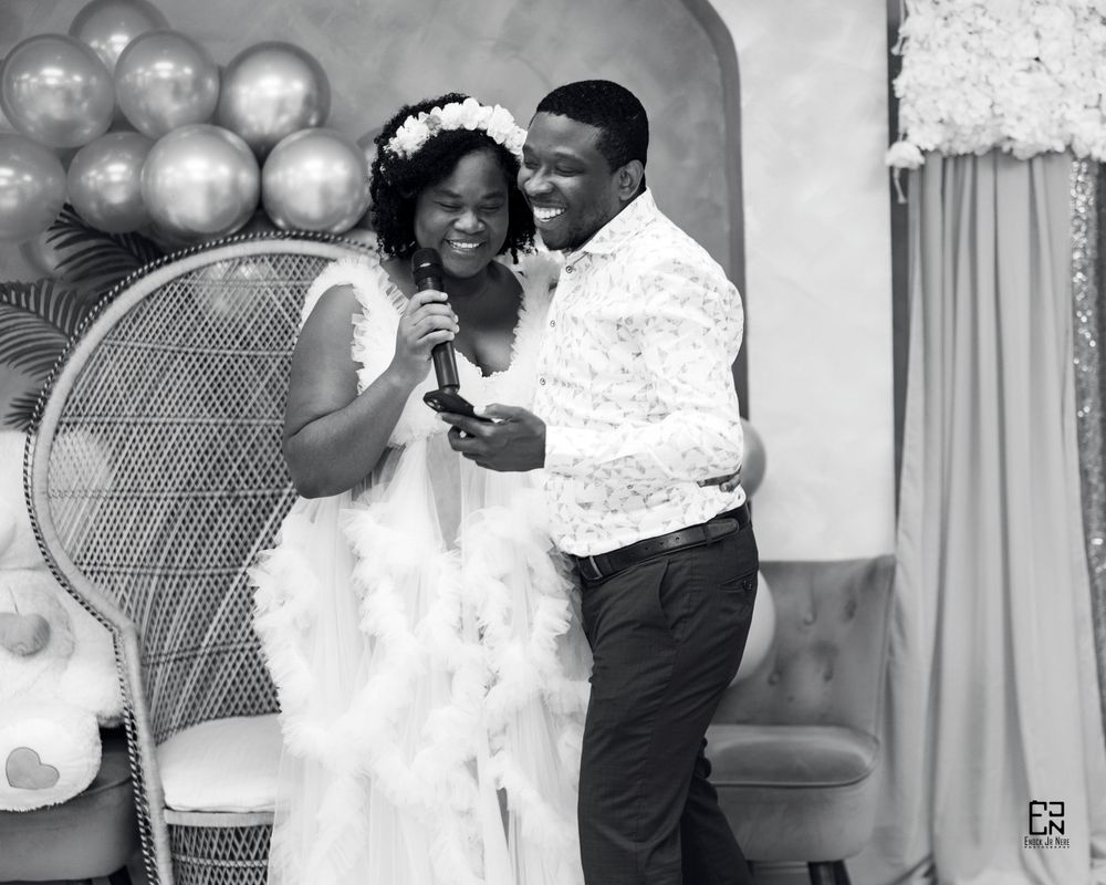 Black and white wedding photo with balloon decor and classic wicker peacock chair.