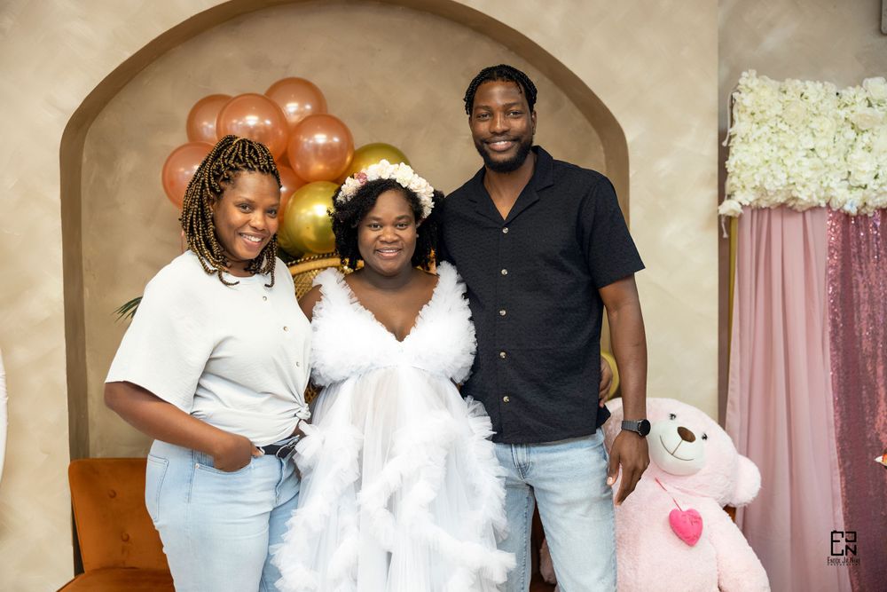 Celebration gathering with balloon arch decor and stuffed teddy bear in the background.