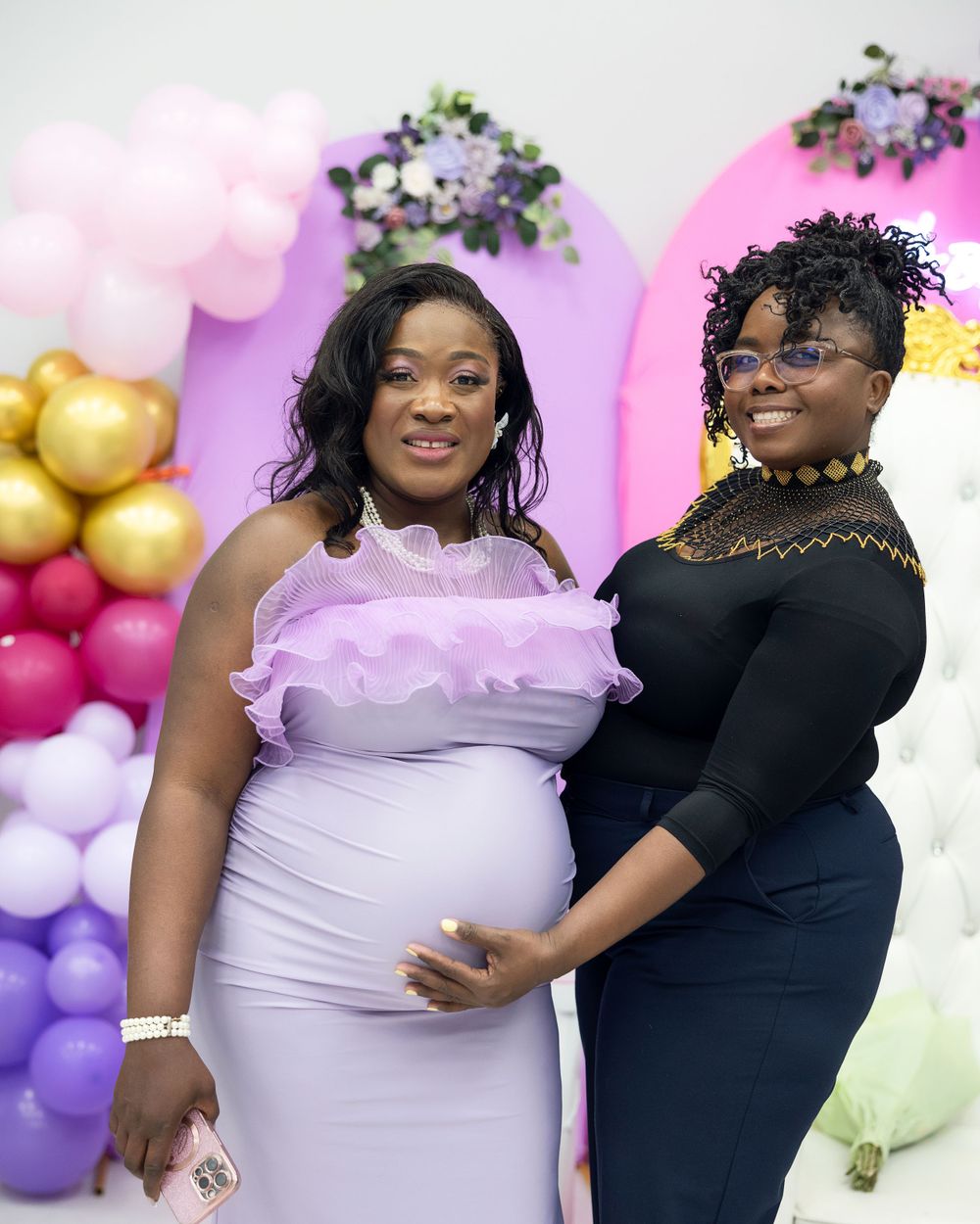 Baby shower celebration with floral arch and pastel balloon arrangements.