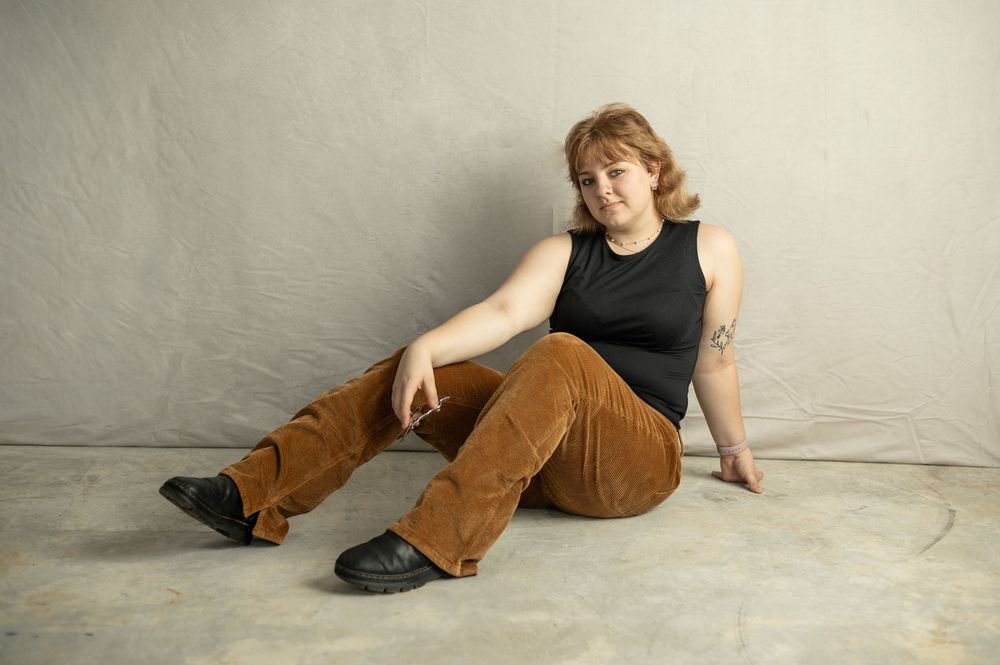Seven fashion poses shown in a photo series featuring a black sleeveless top and brown pants against a light background.