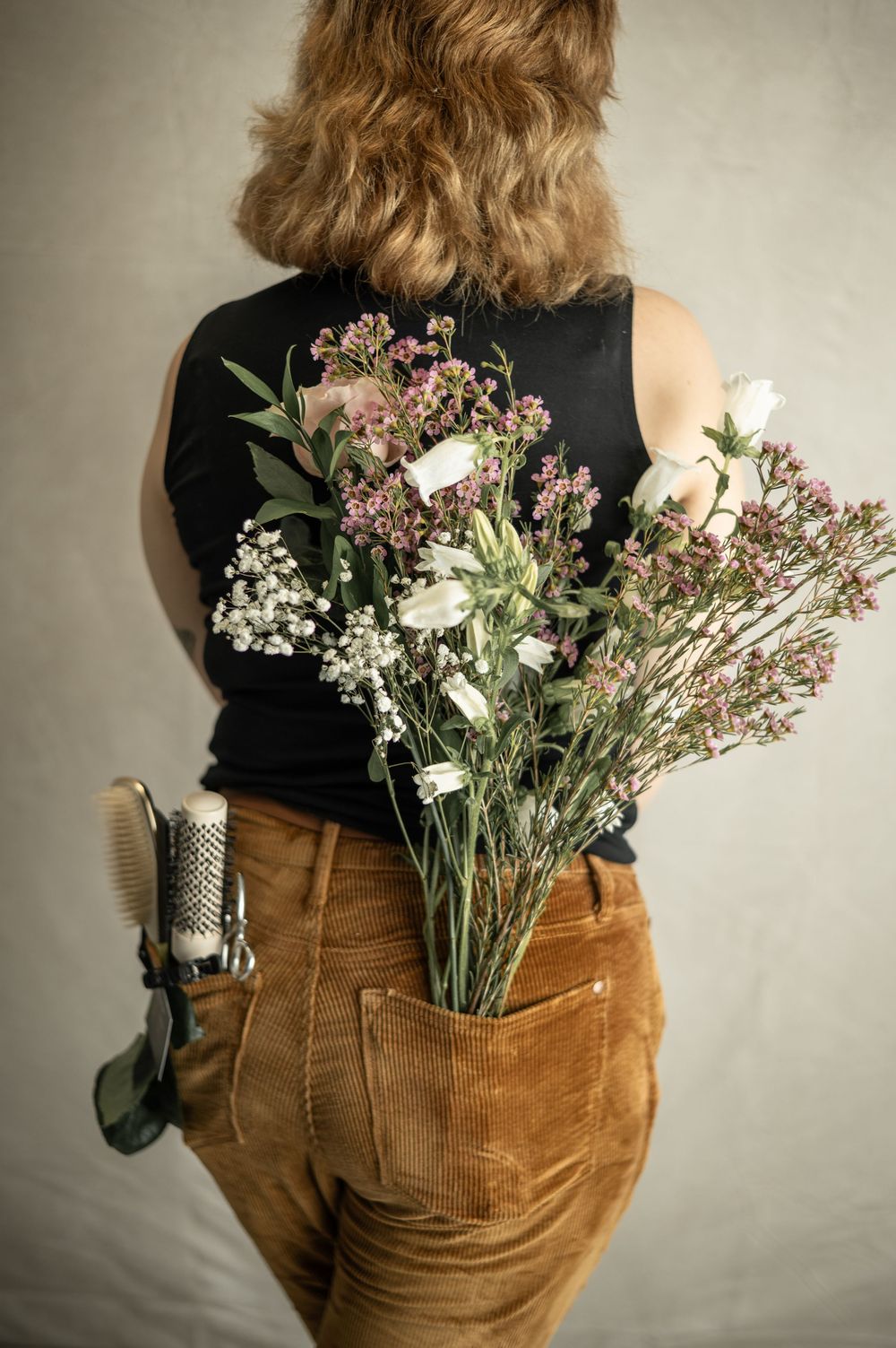 A series of photos showing bouquets of wildflowers tucked into the back pocket of brown corduroy pants.