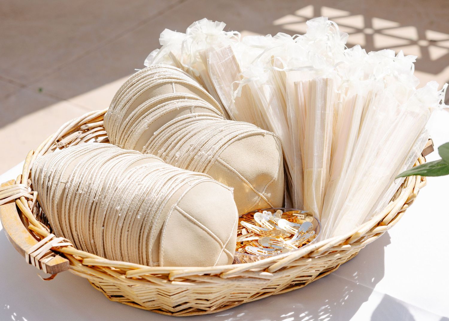 Folded rice paper wrappers and rice noodles arranged in a woven bamboo basket in natural sunlight.