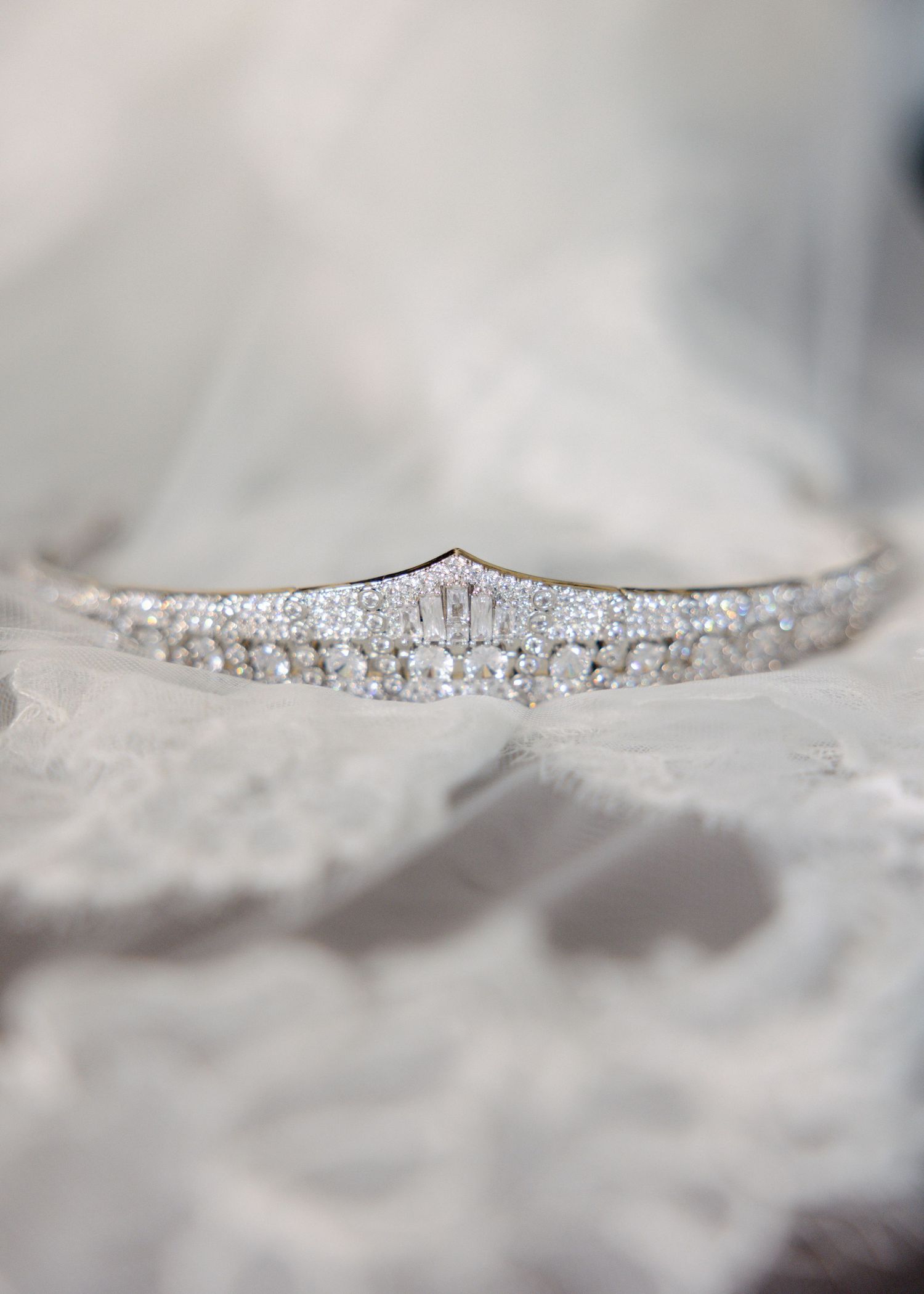 Close-up of a delicate crystal rhinestone trim detail with sparkly elements against a soft blurred background.