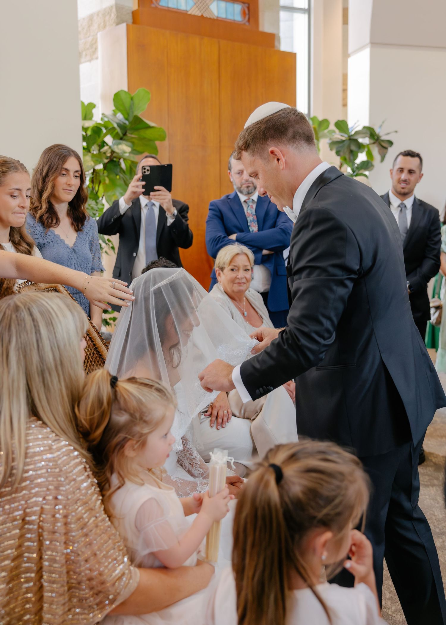 A wedding celebration scene with guests gathered around watching a special moment.