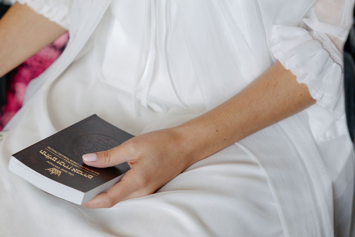 Hands fold a decorative white pillow case with embroidered detailing in a step-by-step sequence.