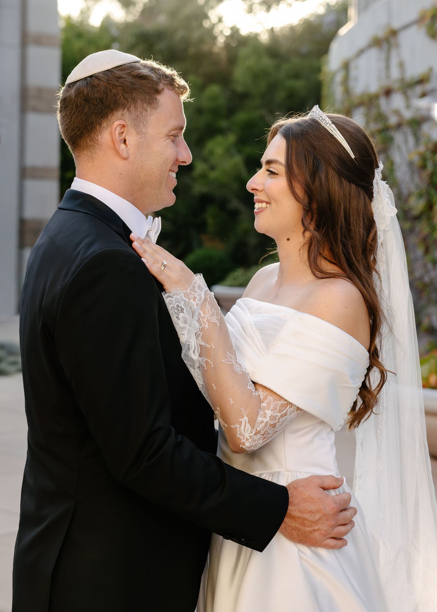Newlywed couple shares tender moments in a series of romantic wedding portraits against white columns outdoors.
