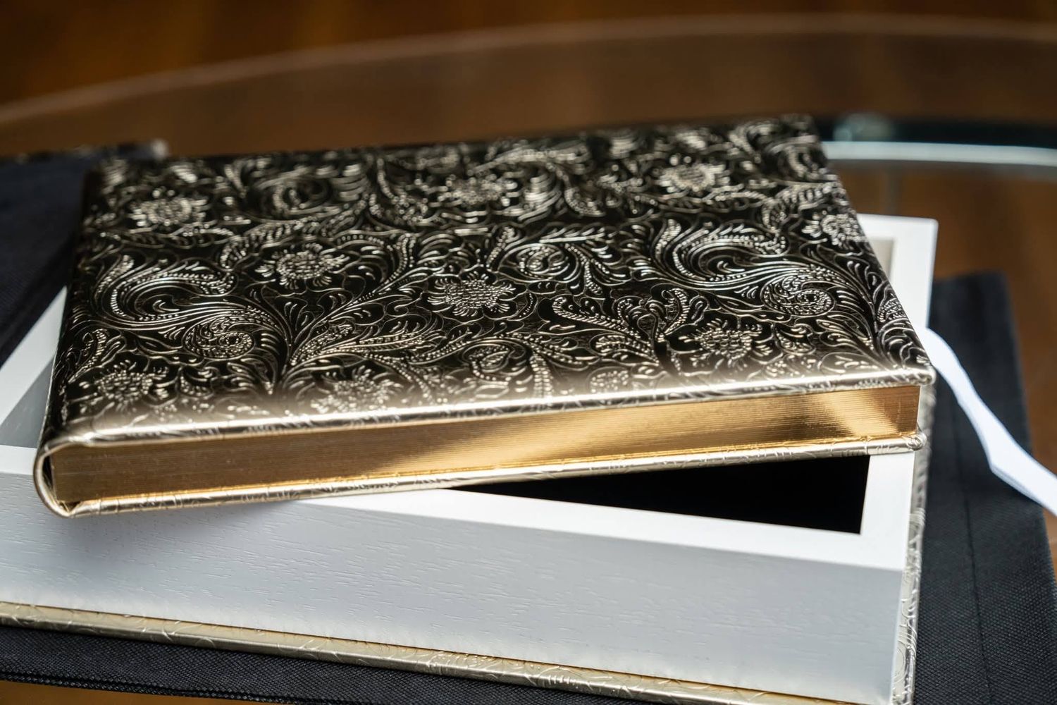 Multiple views of a romantic photo album with black and white photographs displayed against a dark marble surface.