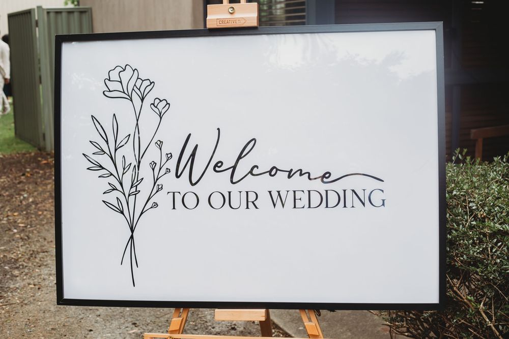 A series of five white-framed wedding welcome signs with floral designs and elegant text displayed in a gallery style row.