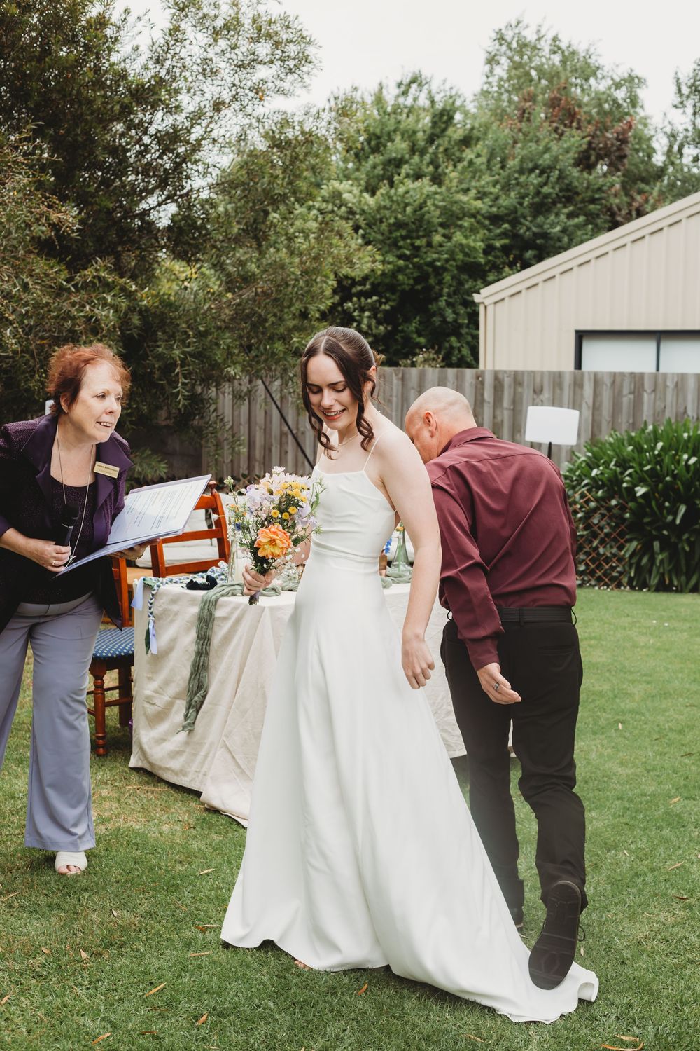 A series of images showing a white wedding dress being bustled and adjusted in an outdoor garden setting.