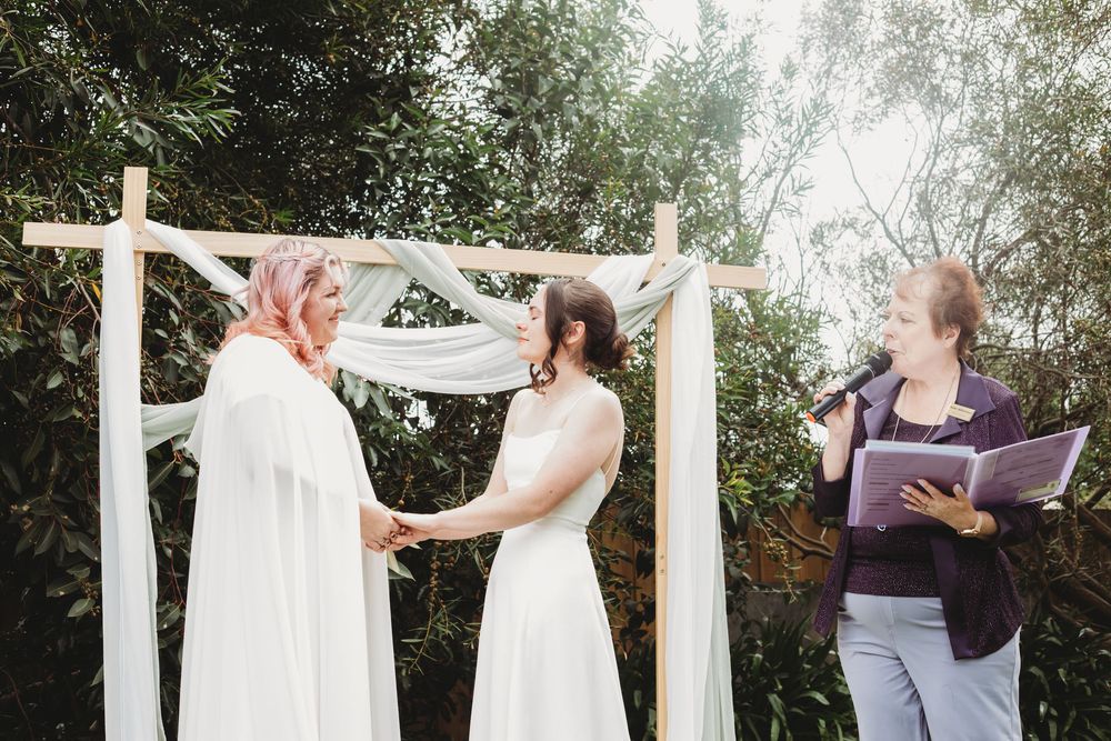 Three wedding photos show the joyful moments of a couple exchanging rings during an outdoor garden ceremony.