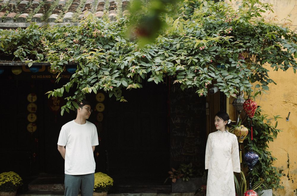 A romantic scene in a traditional Asian courtyard with greenery and old buildings.