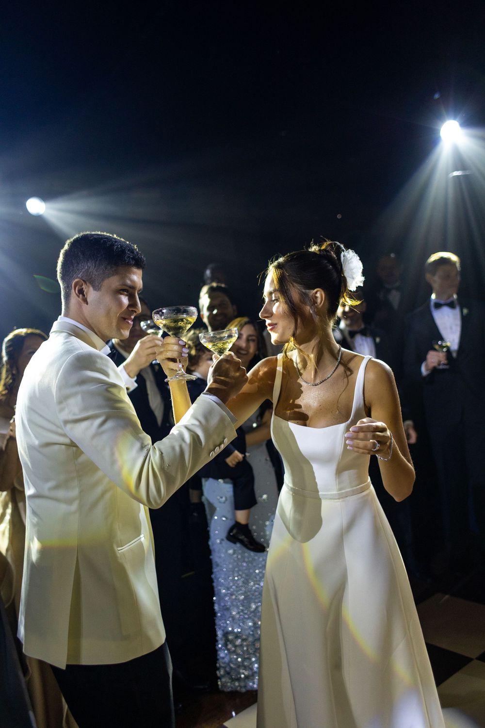 Couple shares a romantic first dance at wedding reception under soft lighting and sparkling decorations.