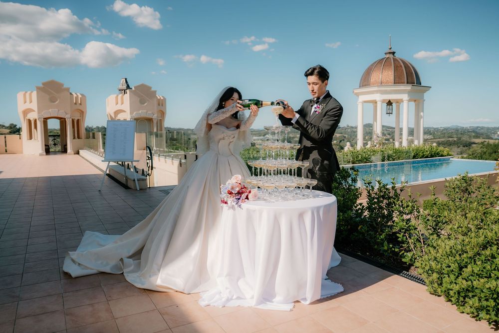 Wedding reception setup at a scenic outdoor venue with white-covered tables and decorative gazebos.