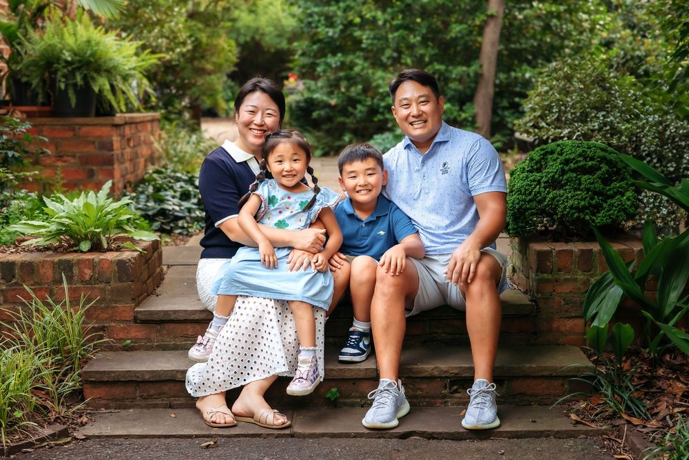 Family of 4 hugging and smiling on brick stairs during family photography session in Athens, GA