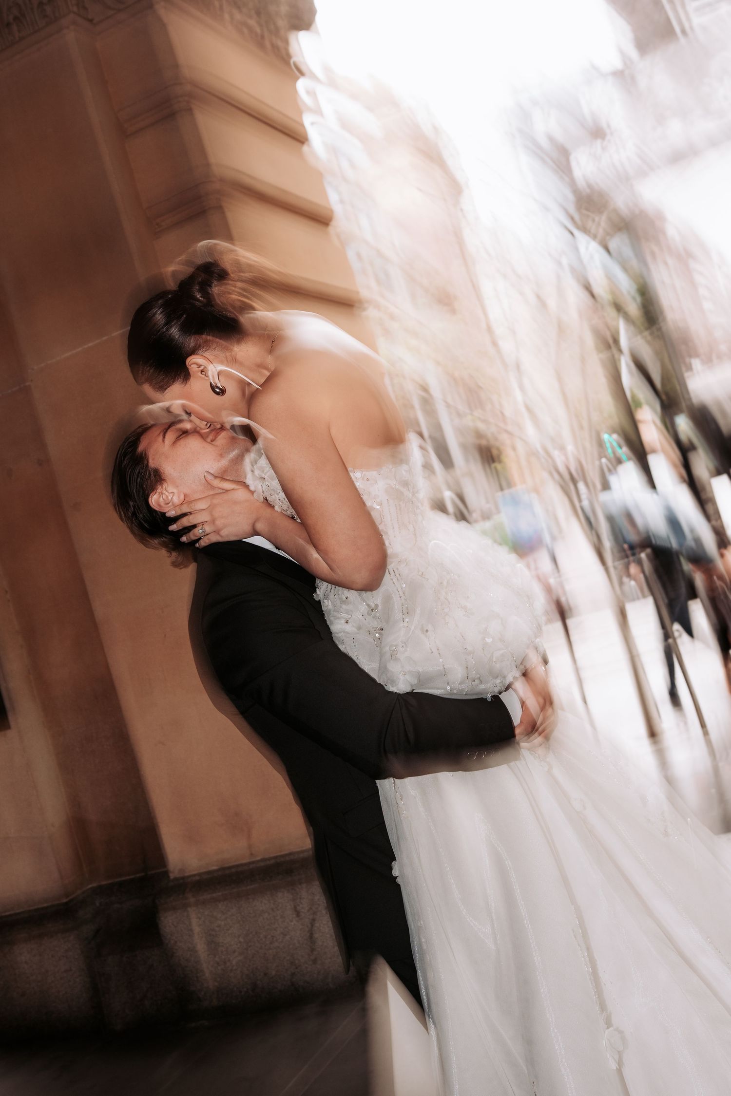 A series of romantic wedding photos showing a couple embracing and dancing in soft, blurred motion against a light background.