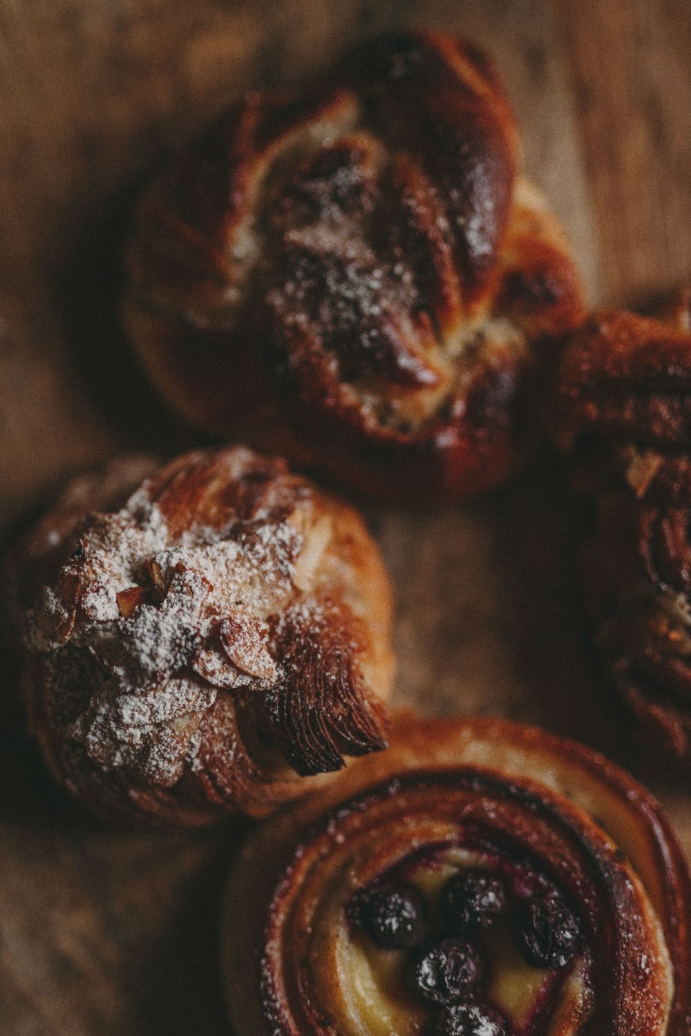 Close-up macro photography of charred brioche rolls with golden crust and dark caramelized spots.