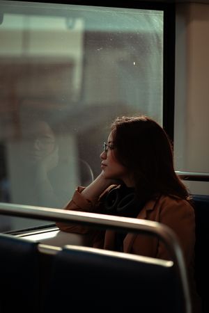South Florida editorial profile, woman lost in thought by train window. Cinematic portrait styled for indie performers by MannyPortraits