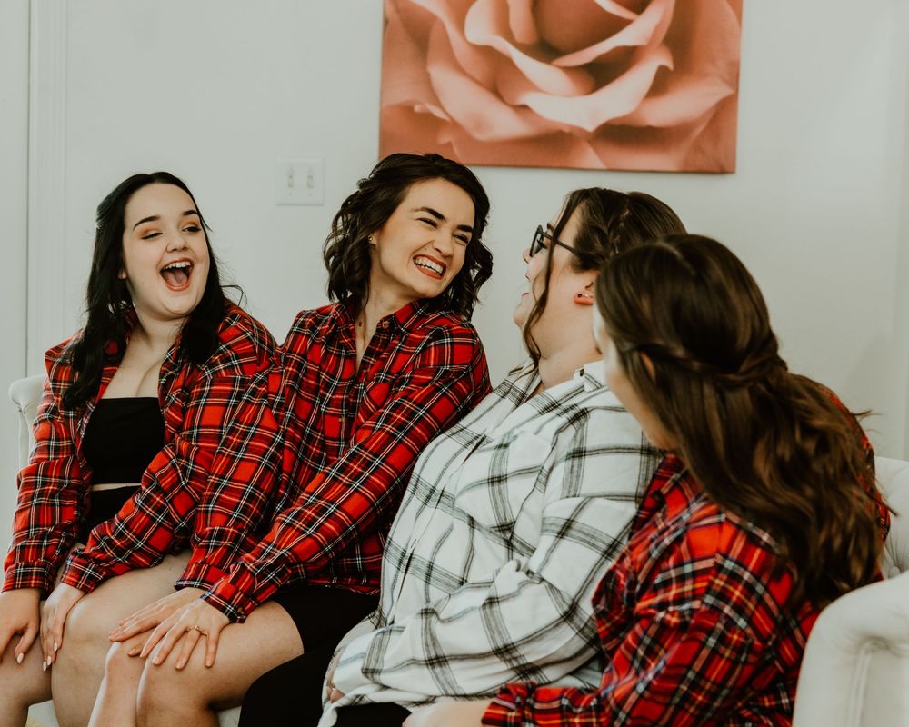 Candid lifestyle photos featuring red plaid and white cozy sweaters capture laughter and joy in winter portraits.