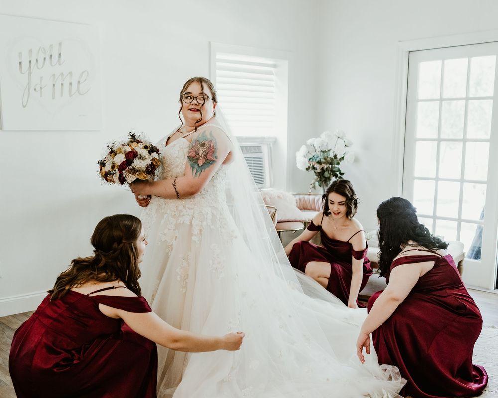 Wedding party reacts emotionally to seeing bride in her white wedding gown for the first time.