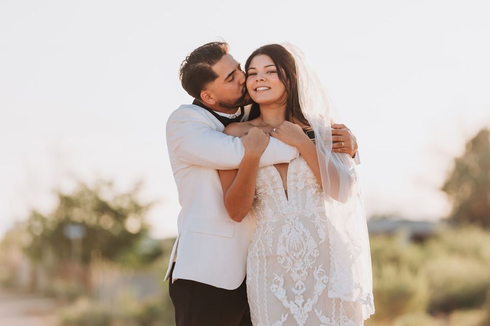 Couple embracing in a romantic sunset photoshoot in an outdoor setting.