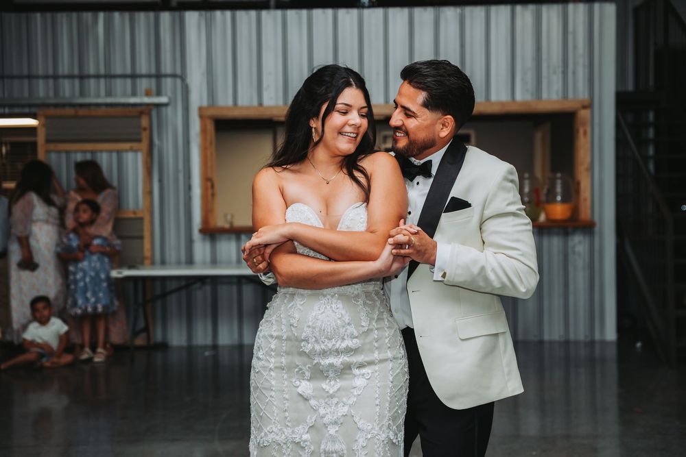Couple sharing an intimate moment on their wedding day in front of a corrugated metal backdrop.