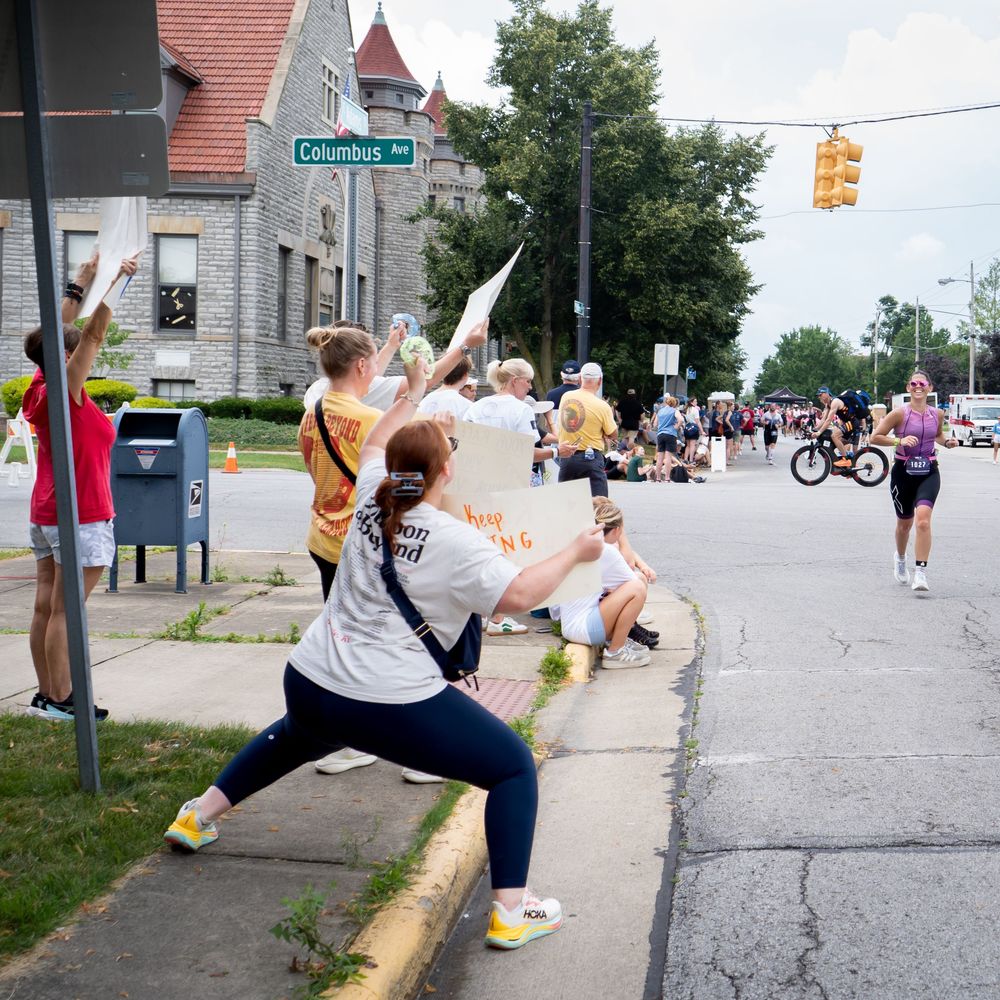 people cheering for racers as they go by on a road.