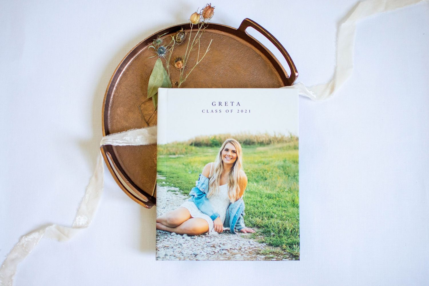 Photo album pages displaying outdoor portrait sessions laid out on a wooden surface.