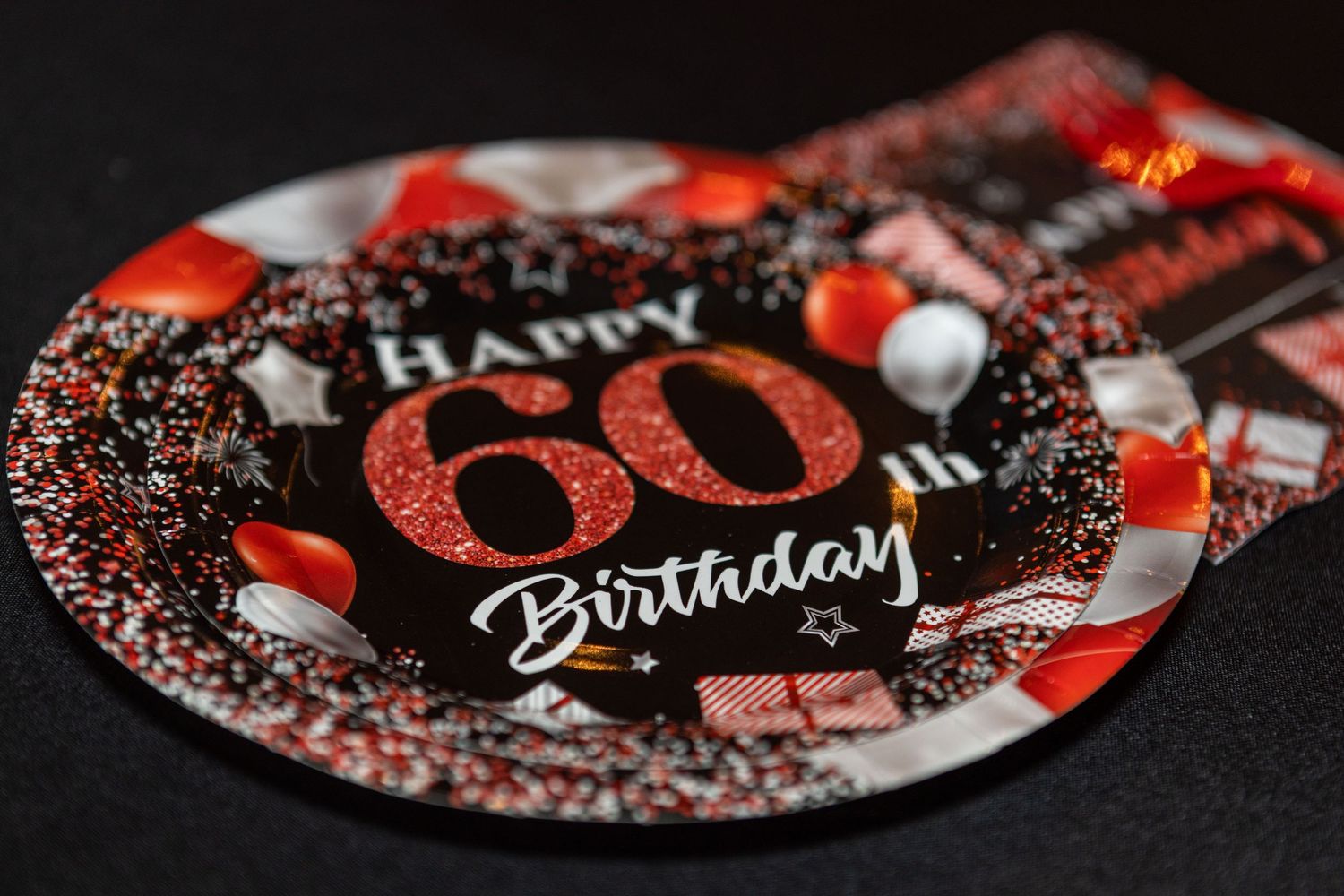 Close-up of decorative birthday plates with red and black sparkly designs.