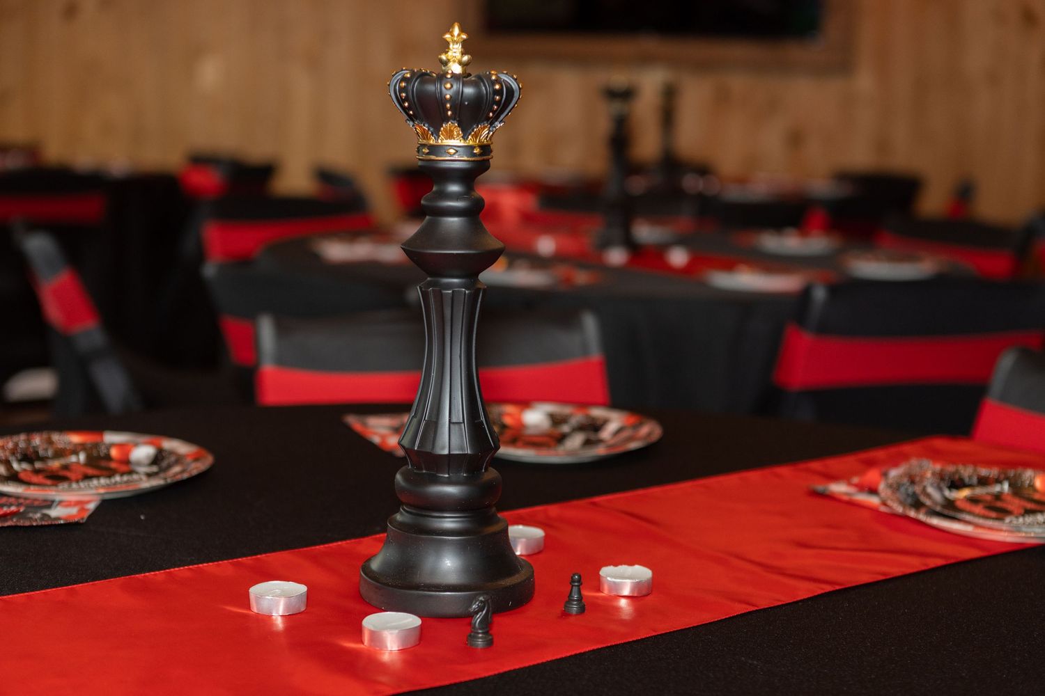 Red and black table settings with decorative centerpieces for an elegant event.