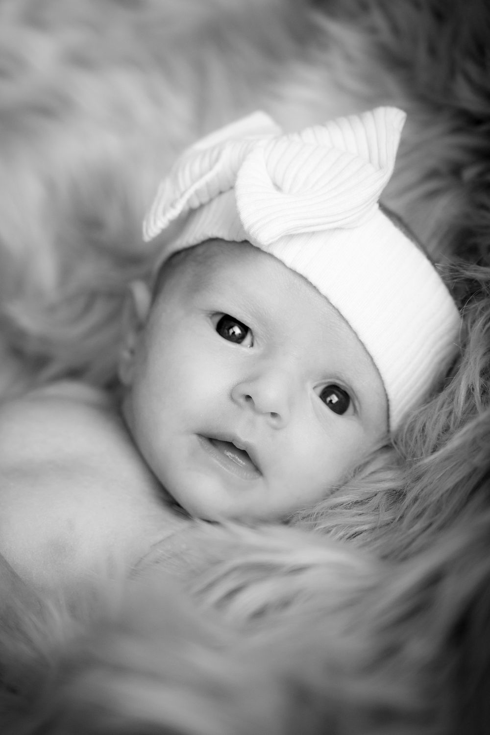 Kokerei Hassel

Schwarz-weiß: Baby auf Fell mit Schleife, ruhiger Moment. Künstlerische Neugeborenenfotografie in der Kokerei Hassel, Gels