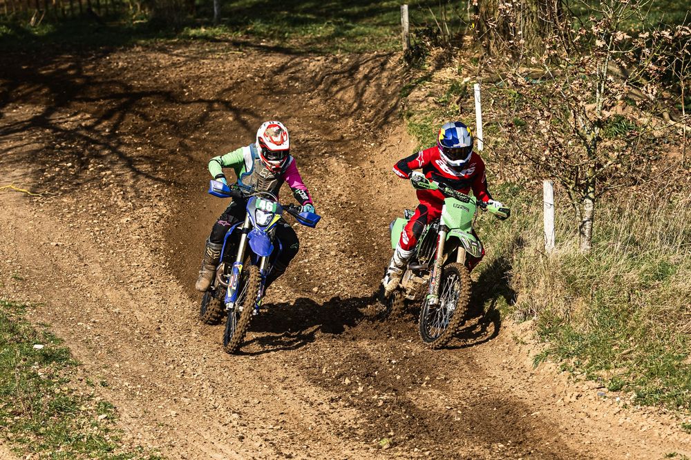 Mountain bikers navigate a winding dirt trail through a wooded area during an outdoor cycling adventure.