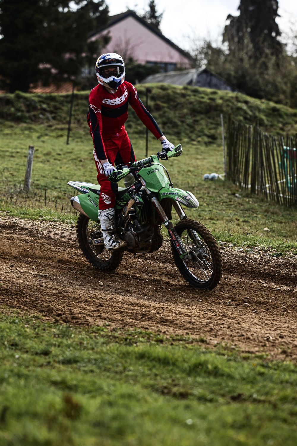 Action sequence of a dirt bike rider navigating a muddy track on a green Kawasaki motorcycle.
