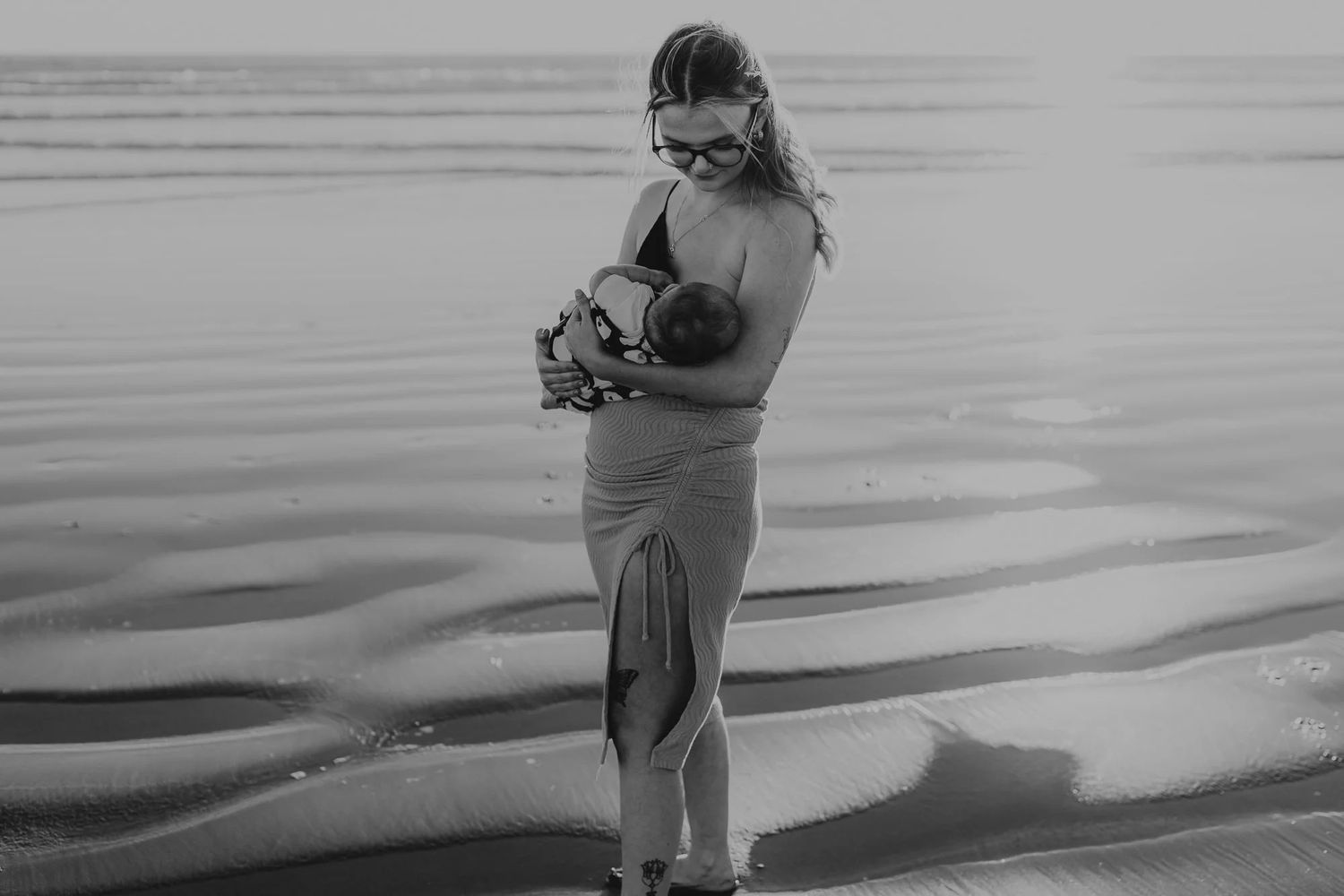 A couple shares a tender moment with their dog on a pristine beach during a vibrant golden sunset.