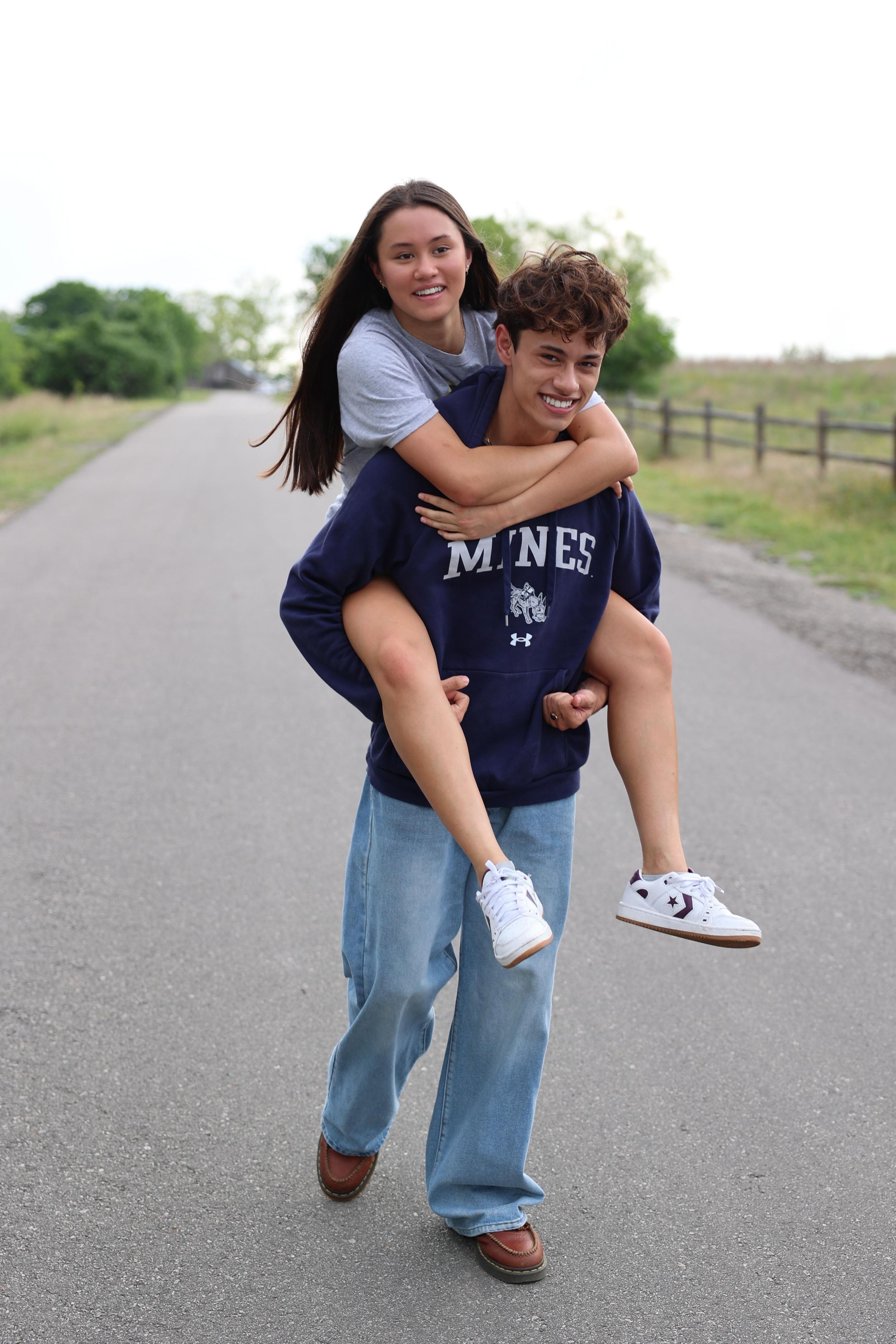 A sequence of playful piggyback images shows two people having fun on a paved path outdoors.